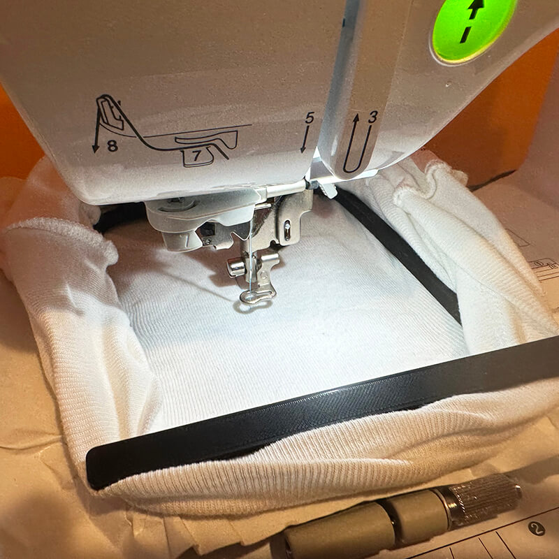 Slide the embroidery hoop underneath the presser foot – then snap the hoop in place. 